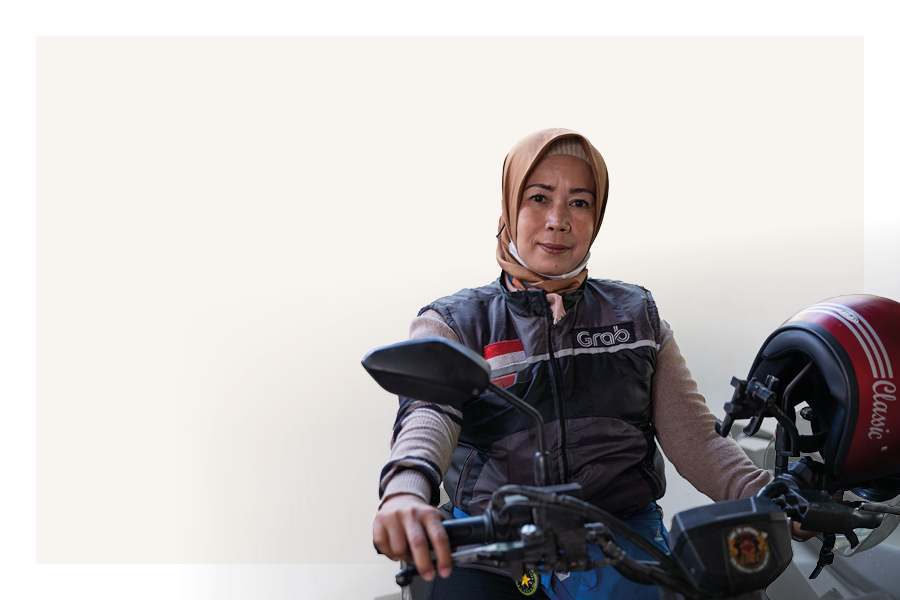 A woman motorcycle taxi driver sitting on her bike